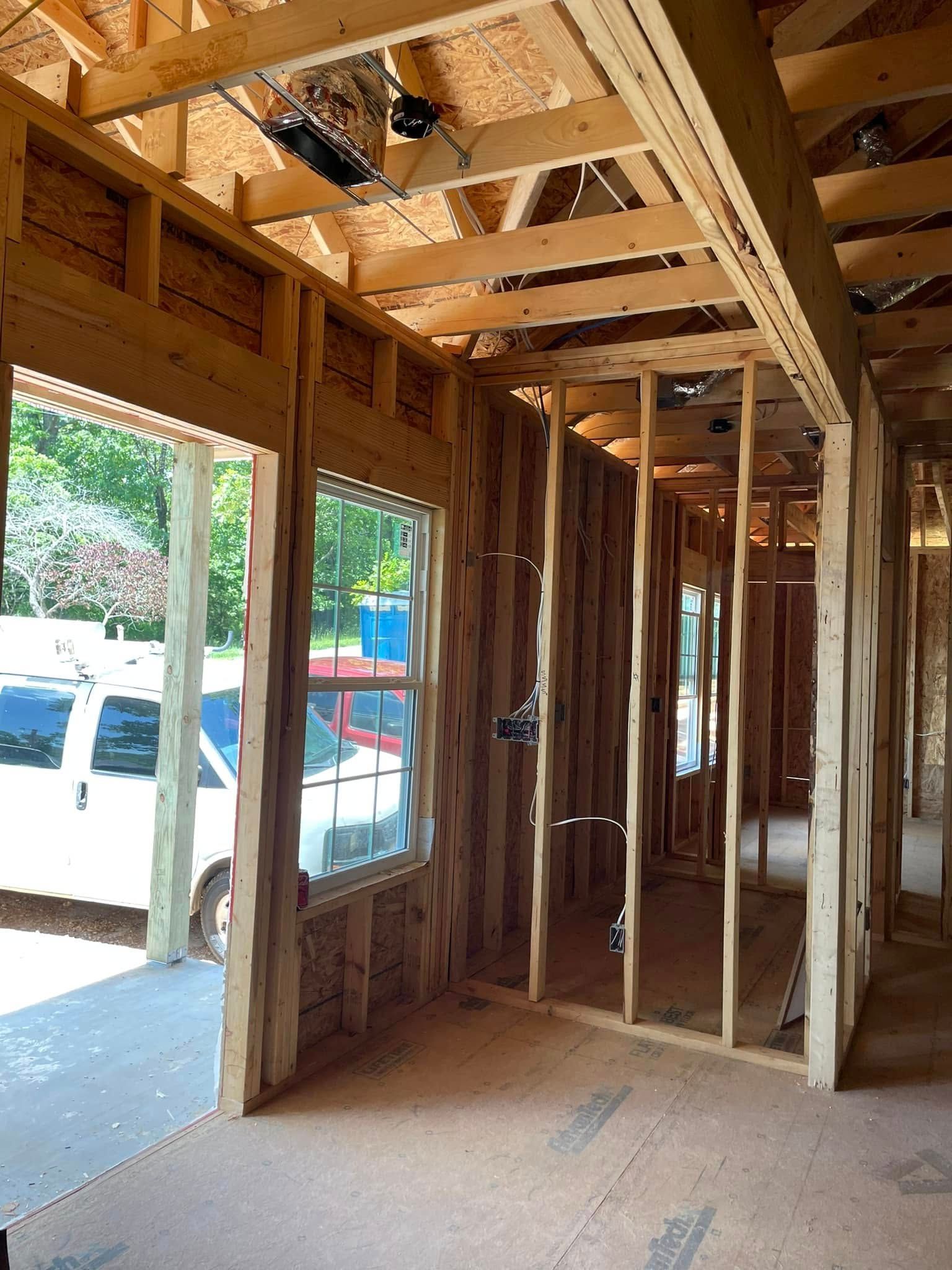 The inside of a house under construction with a white van parked in the background.