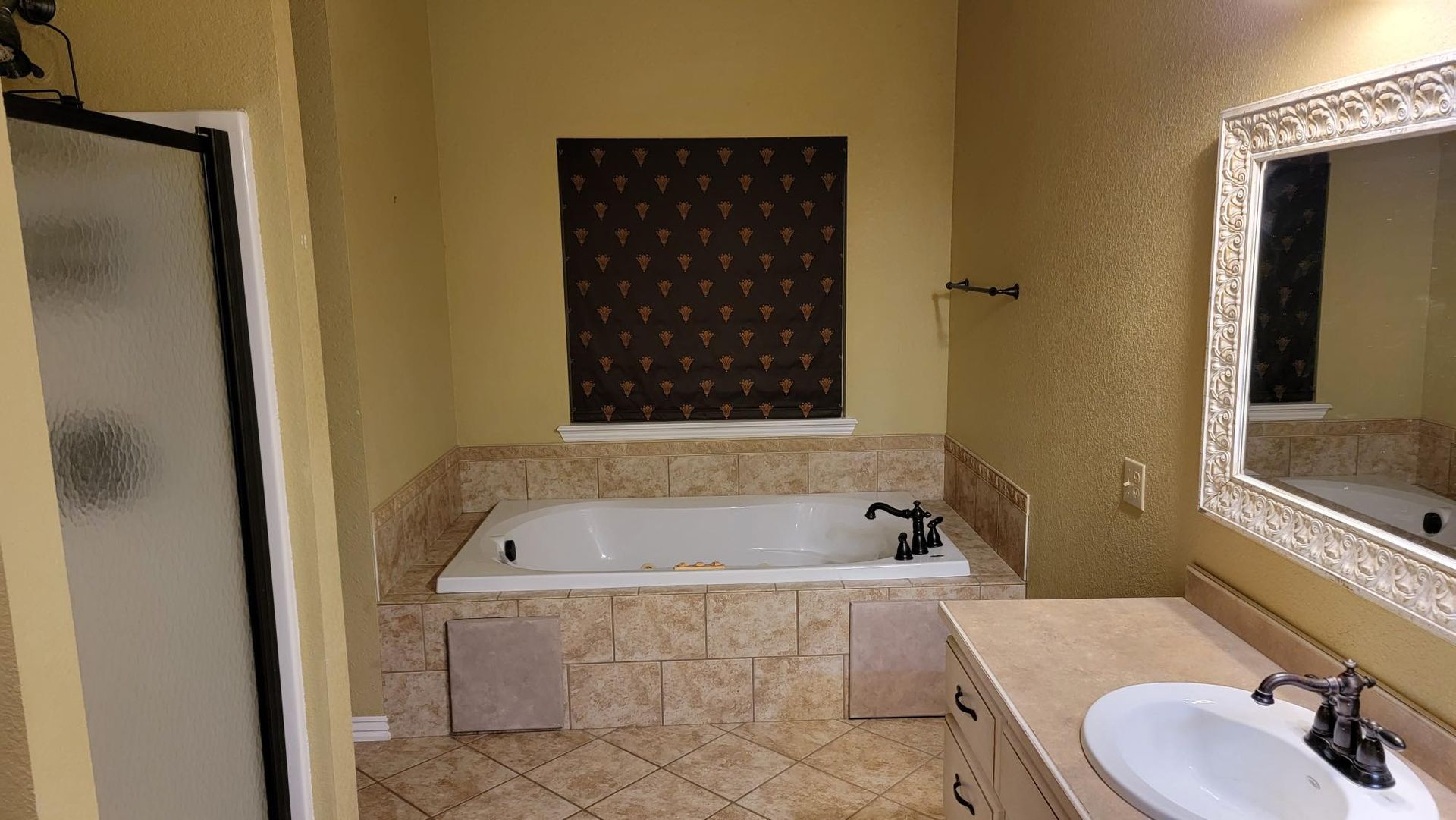 A bathroom with a tub , sink and mirror.