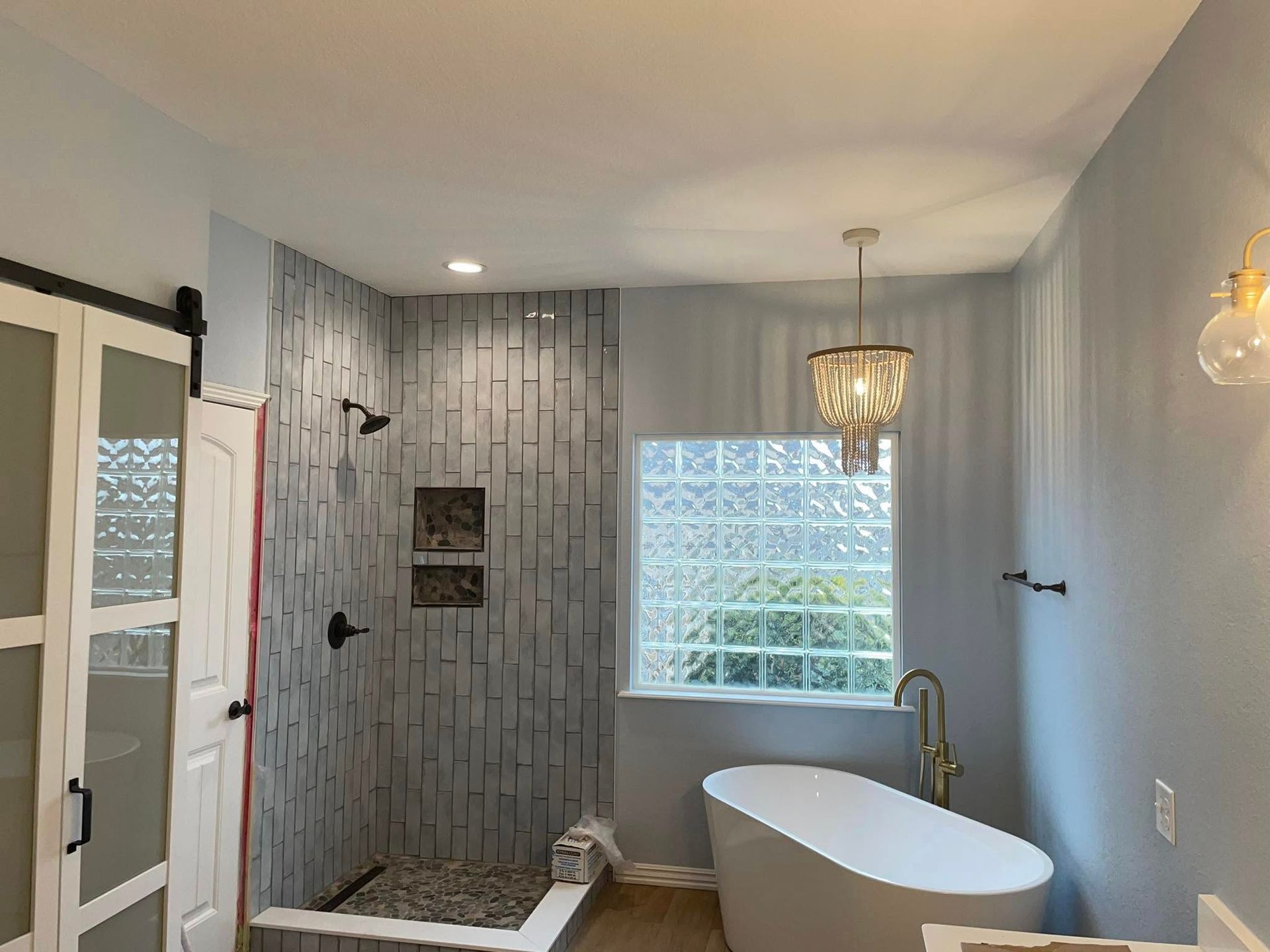 A bathroom with a tub , shower , and window.