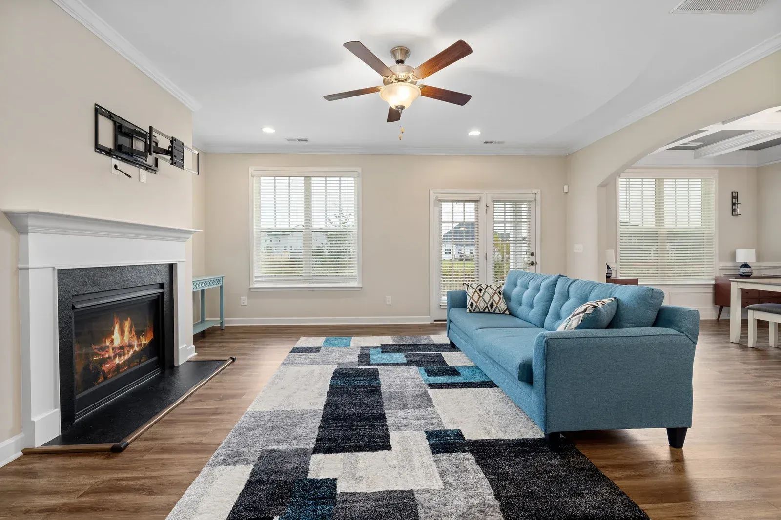 Living room with blue sofa, fireplace, and patterned rug.