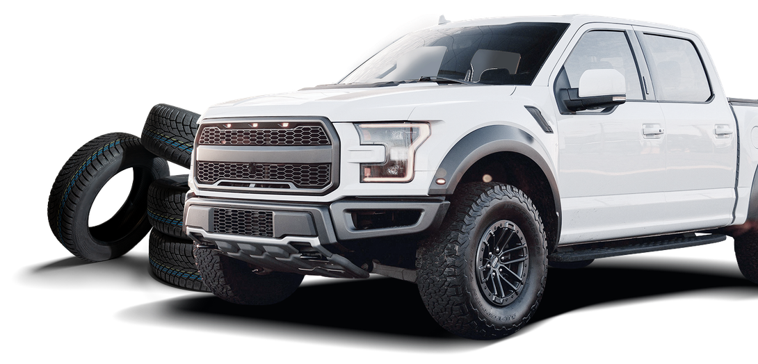 White Ford F-150 truck parked next to stack of tires | Marlin's Auto Service