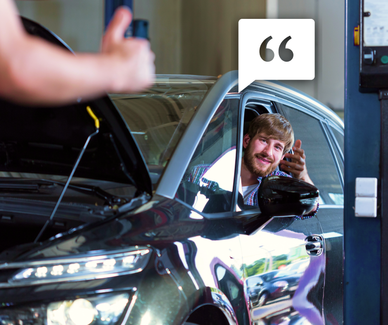 Man smiling in parked car inside garage talking with technician giving a thumbs up, ready for service services in Lynden, WA | Marlin's Auto Service