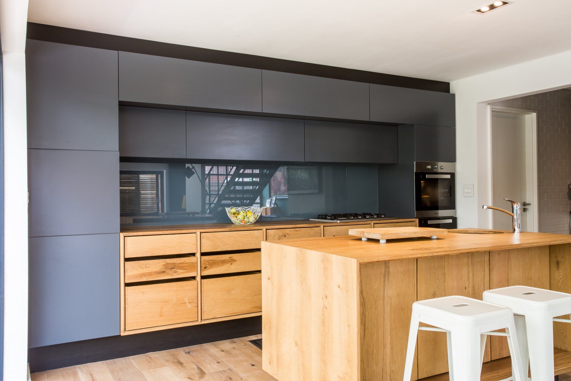 A kitchen with a wooden island and stools. 7 Lemon Lane – Newlands