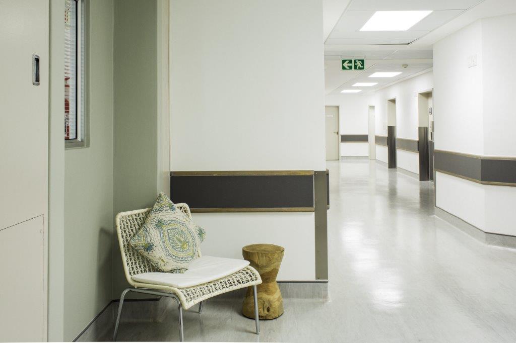 A hospital hallway with a chair and a stool in the corner. Life Vincent Pallotti – Maternity & Neonatal ICU
