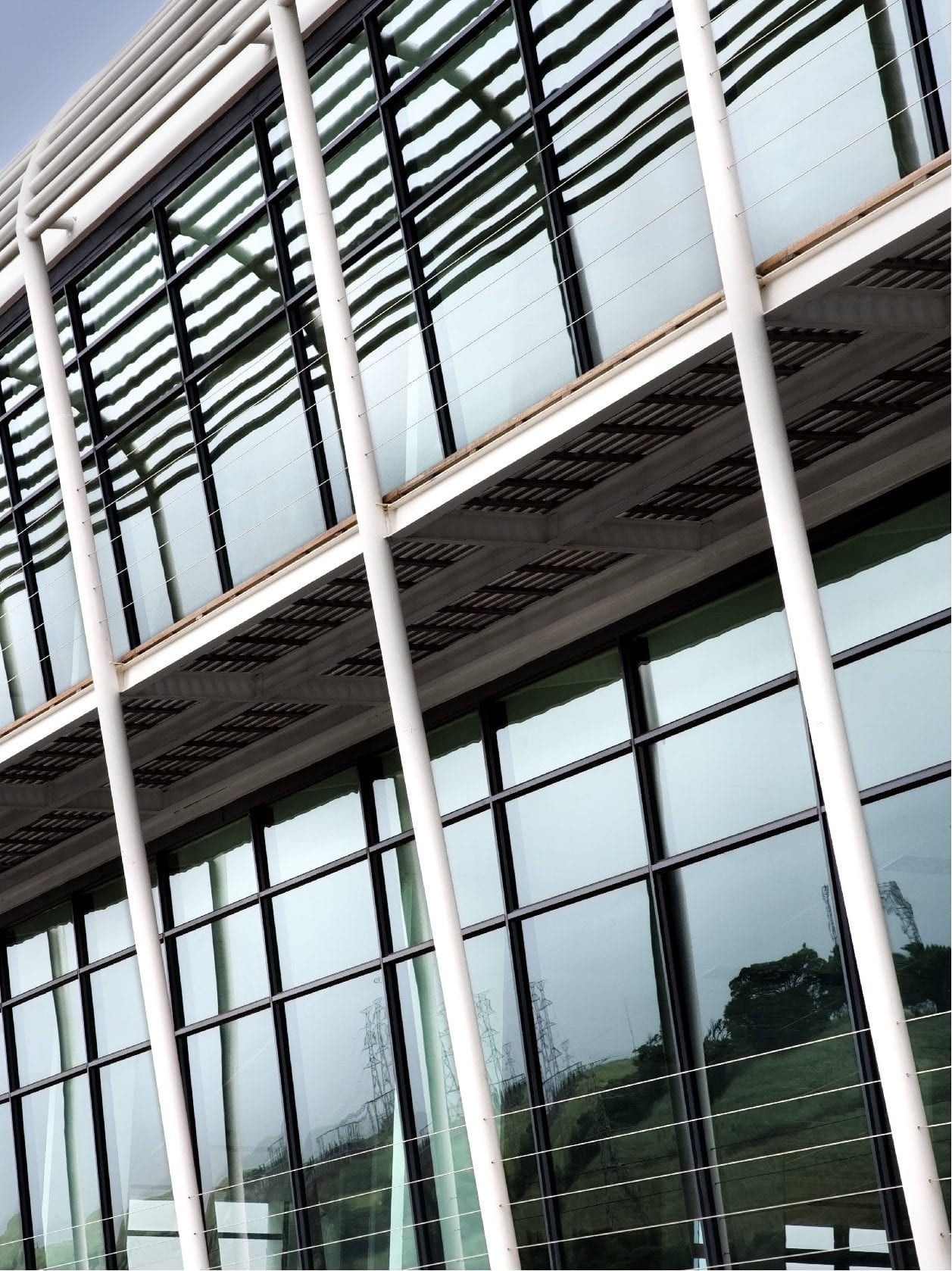 A building with a lot of windows and a reflection of trees. SARS – Umhlanga