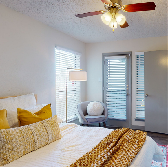 A bedroom with a bed and a ceiling fan