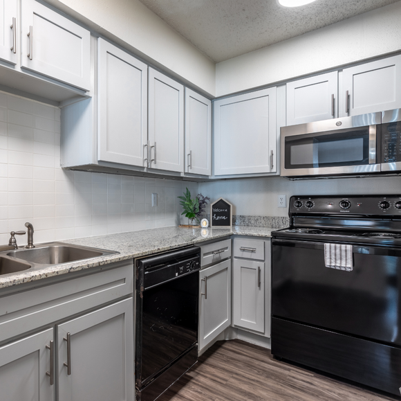 A kitchen with black appliances and white cabinets