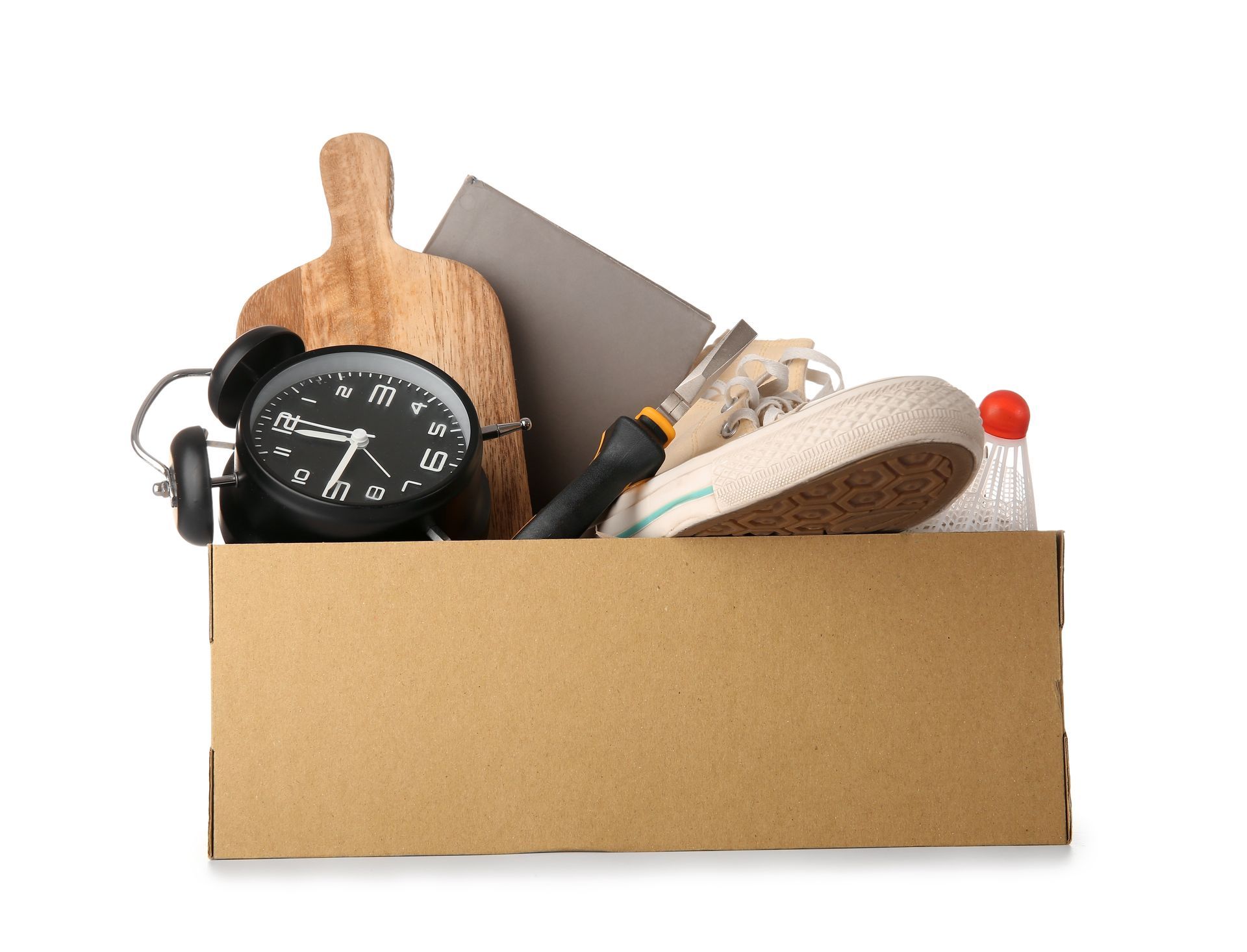 A cardboard box filled with a clock , a screwdriver , a shoe and other items.