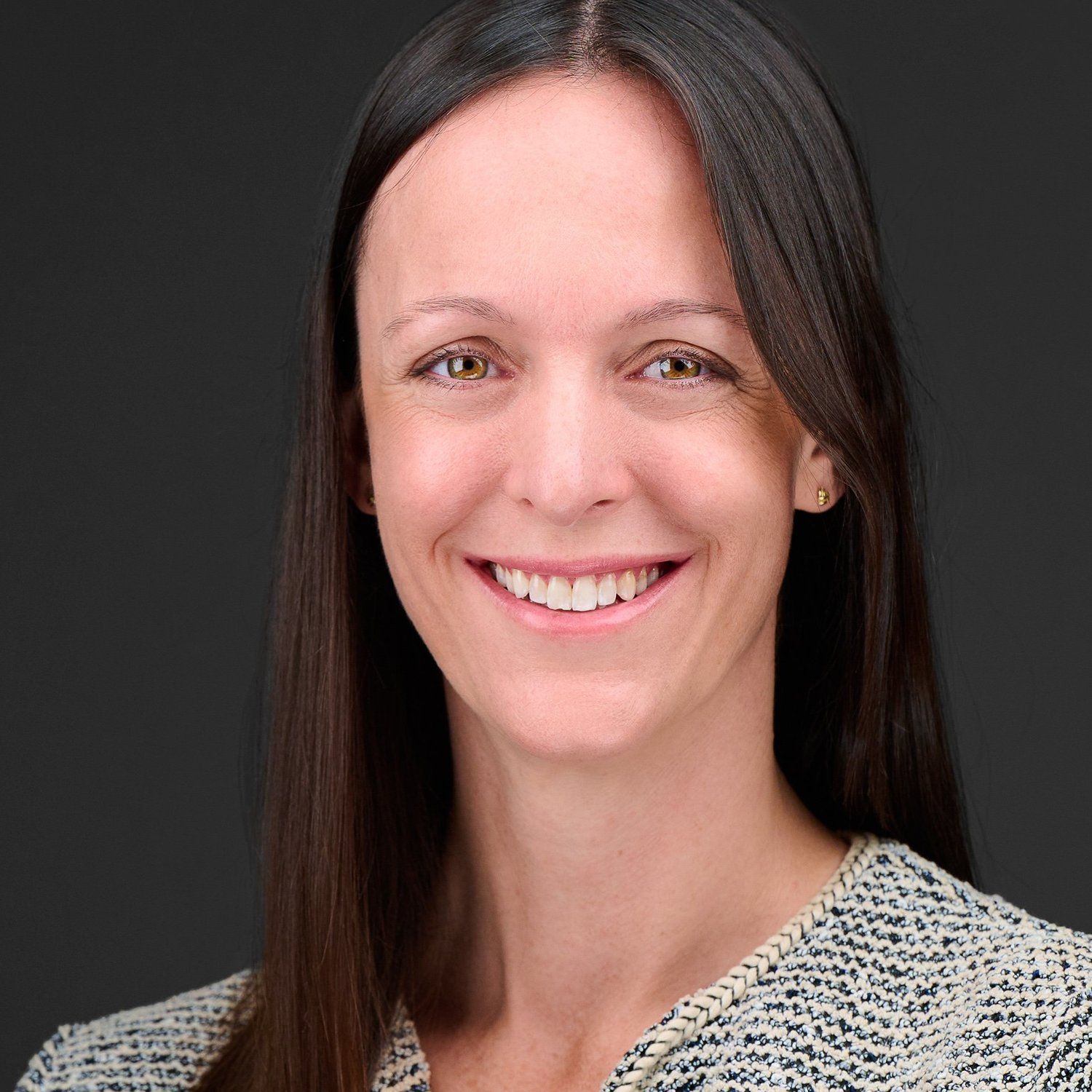 A woman with long hair is smiling for the camera.