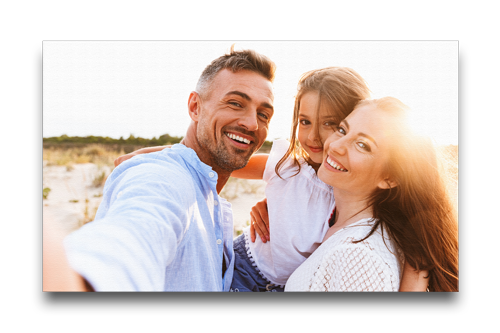A family is taking a selfie on the beach.