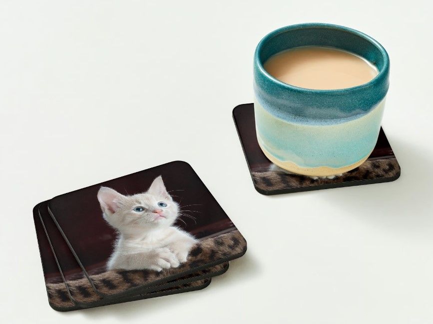 Une tasse de café et une carte postale sur une table en bois.