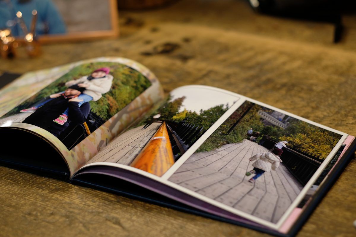 Une femme est assise sur un canapé en train de lire un livre.