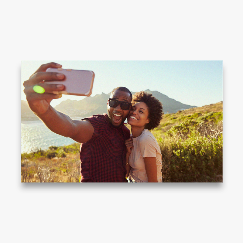 A man and a woman are taking a selfie with a cell phone.
