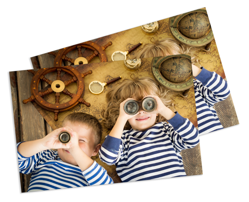 Two children are laying on the floor looking through binoculars.