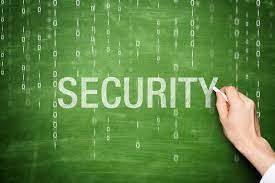 A person is writing the word security on a green chalkboard.