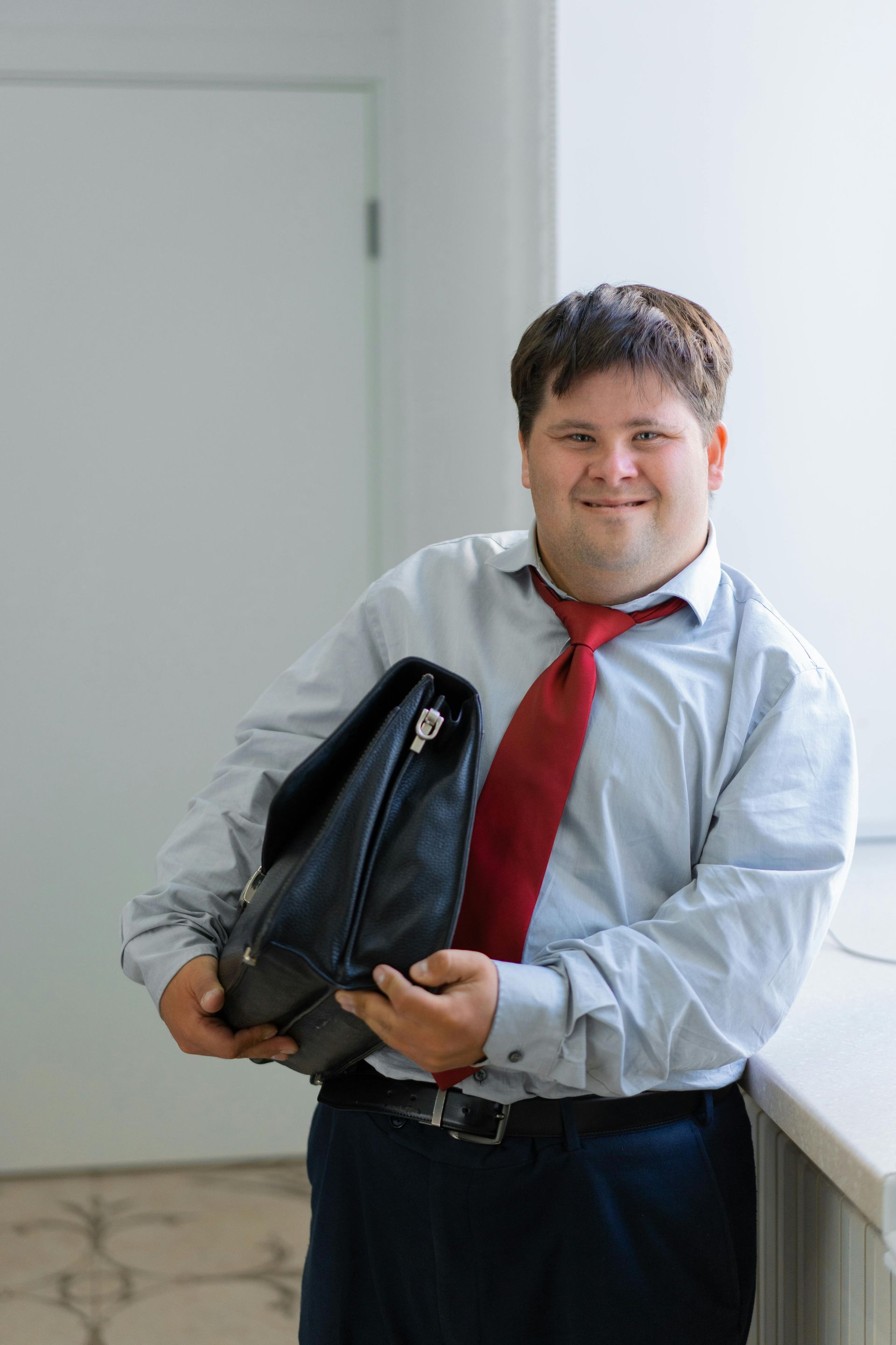 A man in a suit and tie is holding a briefcase.