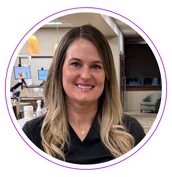 Kylie smiling, wearing black scrubs, at the Small and Piers dental practice.