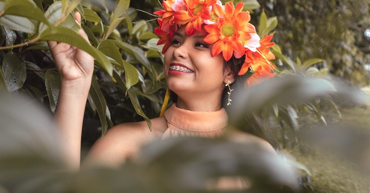 A woman wearing a flower crown is standing in the woods.