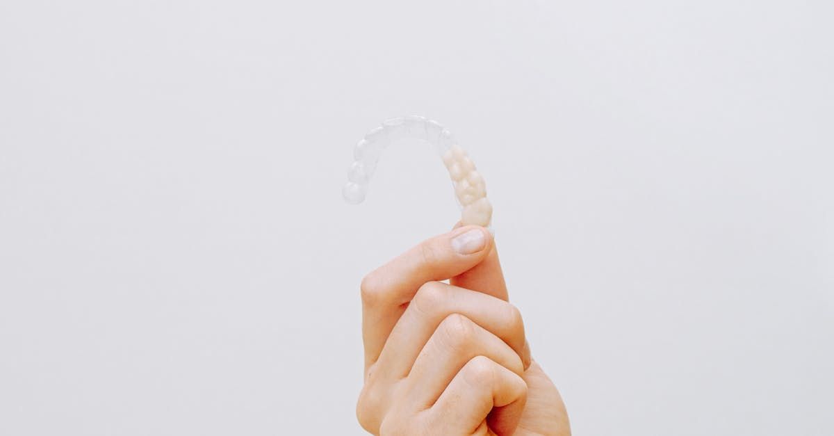 A person is holding a clear brace in their hand.