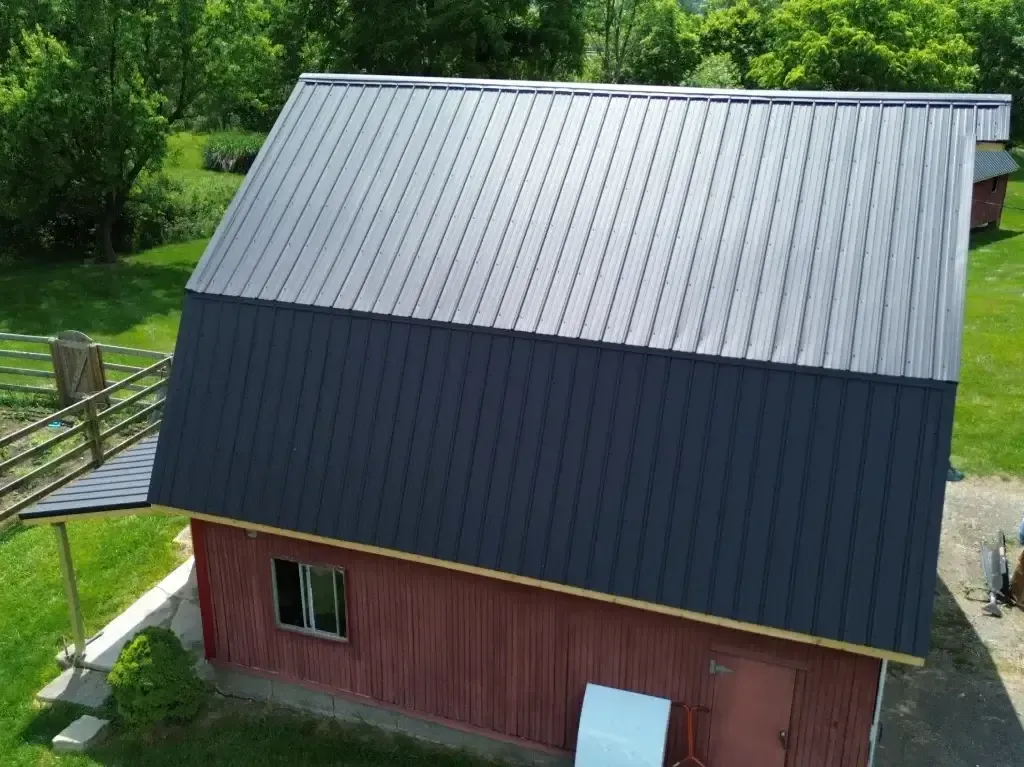 An aerial view of a barn with a black roof.