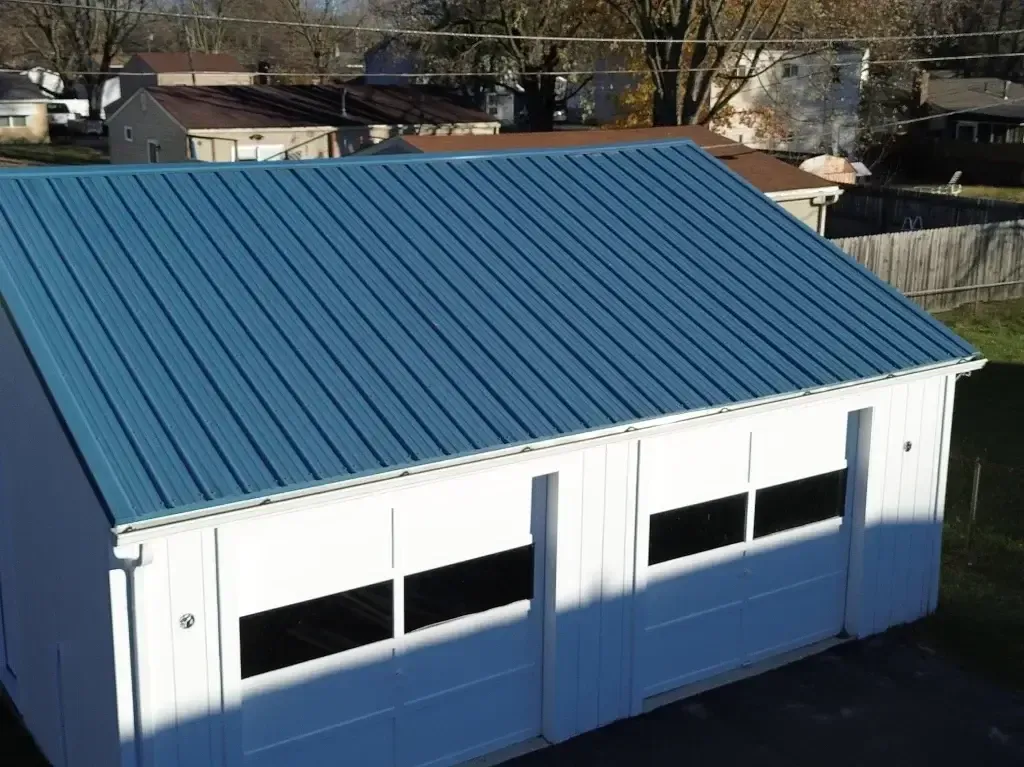 A white garage with a blue roof and black windows.