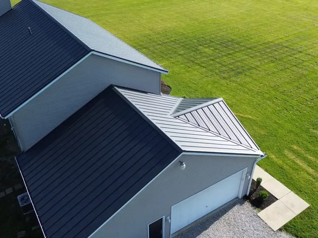 An aerial view of a house with a black roof and a white garage door.