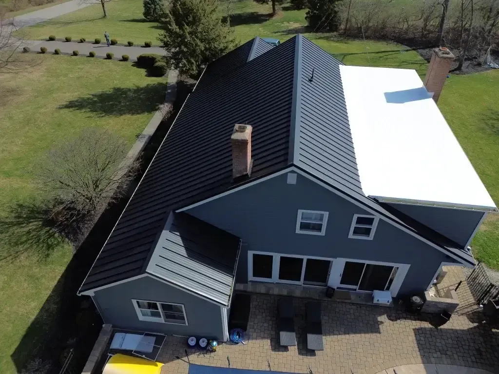 An aerial view of a house with a white roof