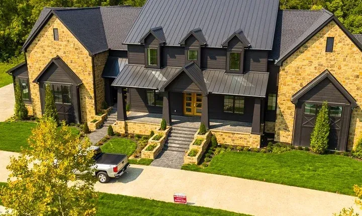 An aerial view of a large house with a truck parked in front of it.