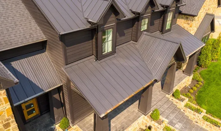 An aerial view of a large house with a metal roof.