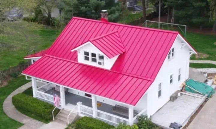 An aerial view of a white house with a red roof.