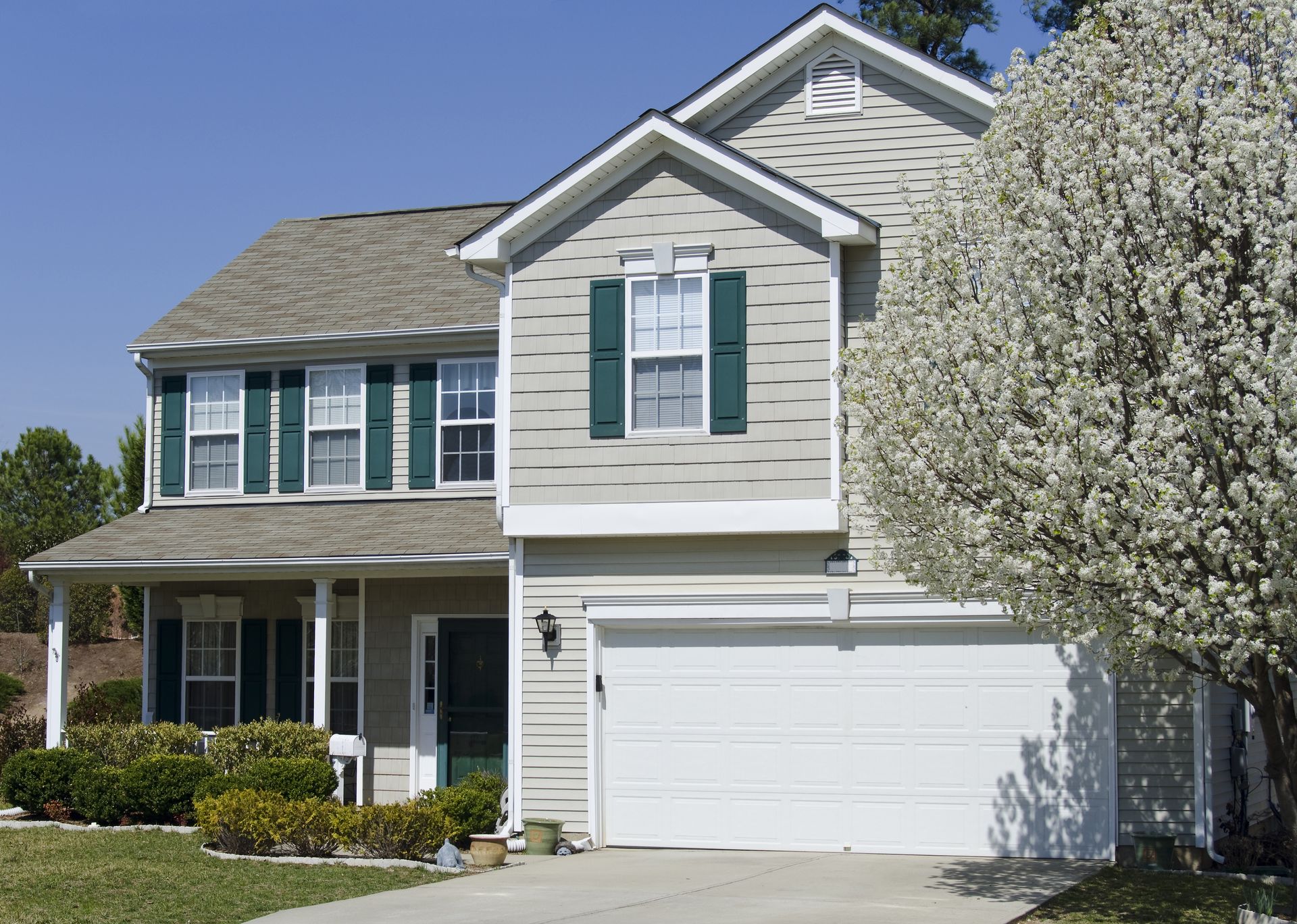 A house with a white garage door and green shutters