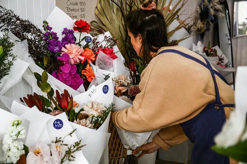 Woman is arranging flowers in a flower shop — Flowers in Fairy Meadow, NSW