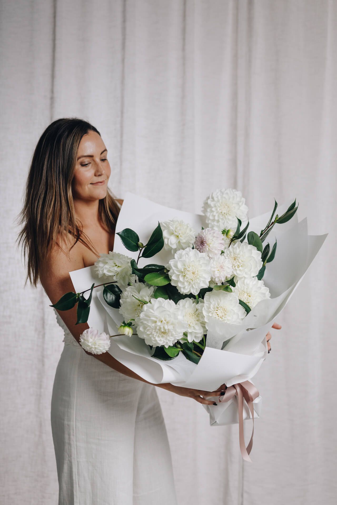 A Woman Holding a Bouquet of White Flower — Florist in Wollongong, NSW