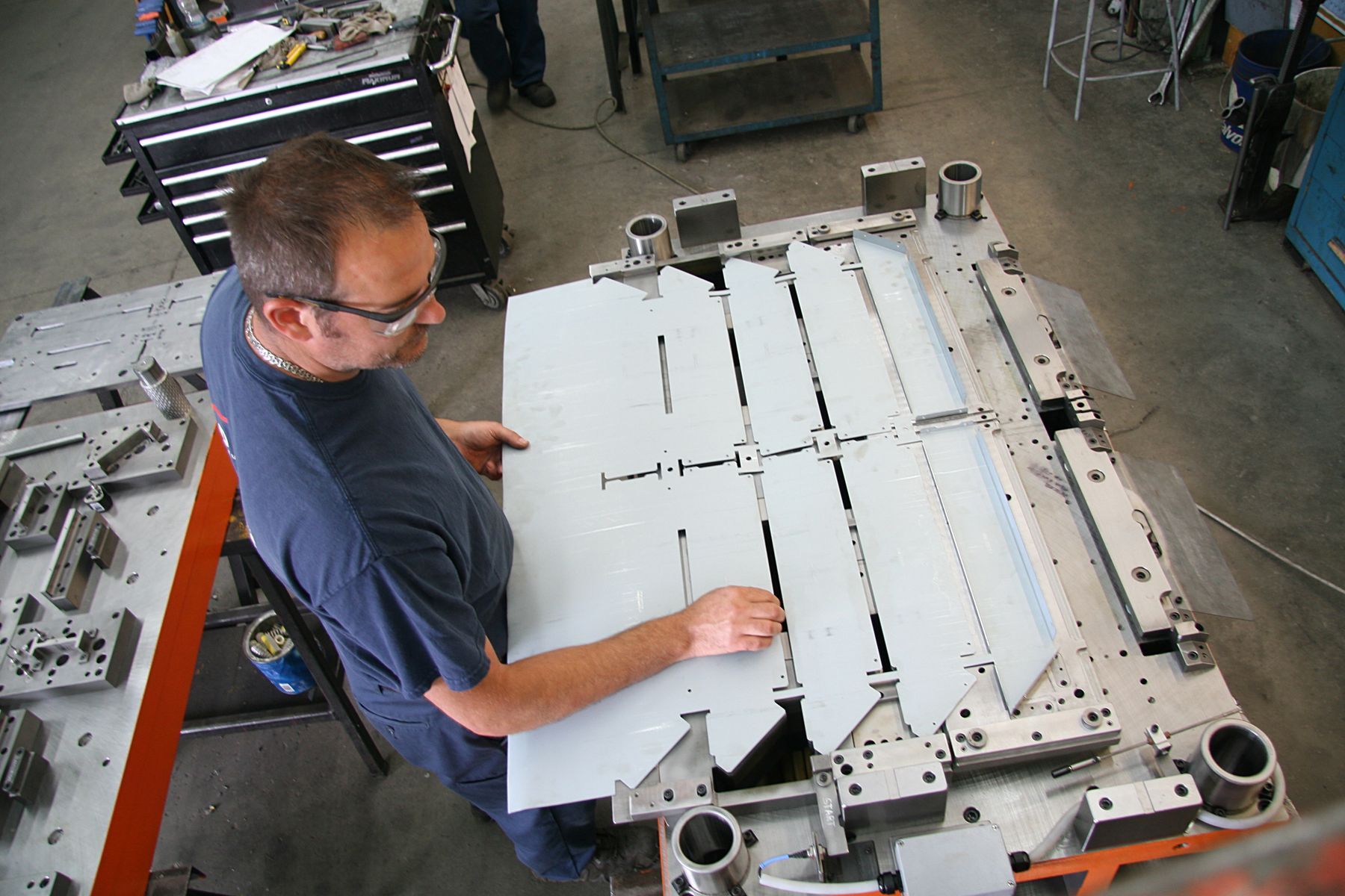 Un homme travaille sur un morceau de métal dans une usine