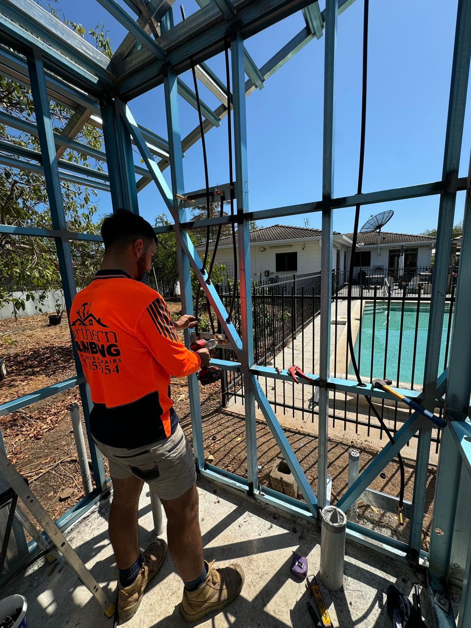 Plumber Working Under a Kitchen Sink — Northern Plumbing Maintenance & Repairs in Leanyer, NT