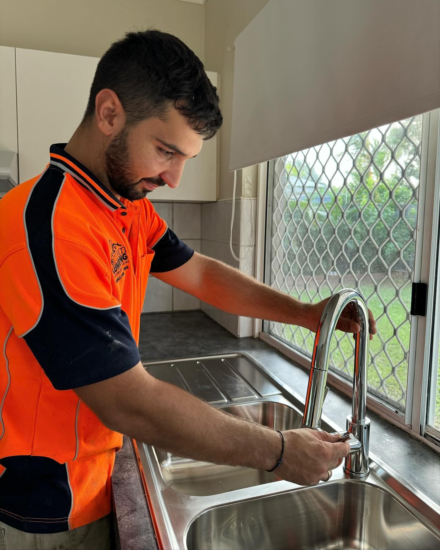 Person Holds a Red and Black Handheld — Northern Plumbing Maintenance & Repairs in Leanyer, NT