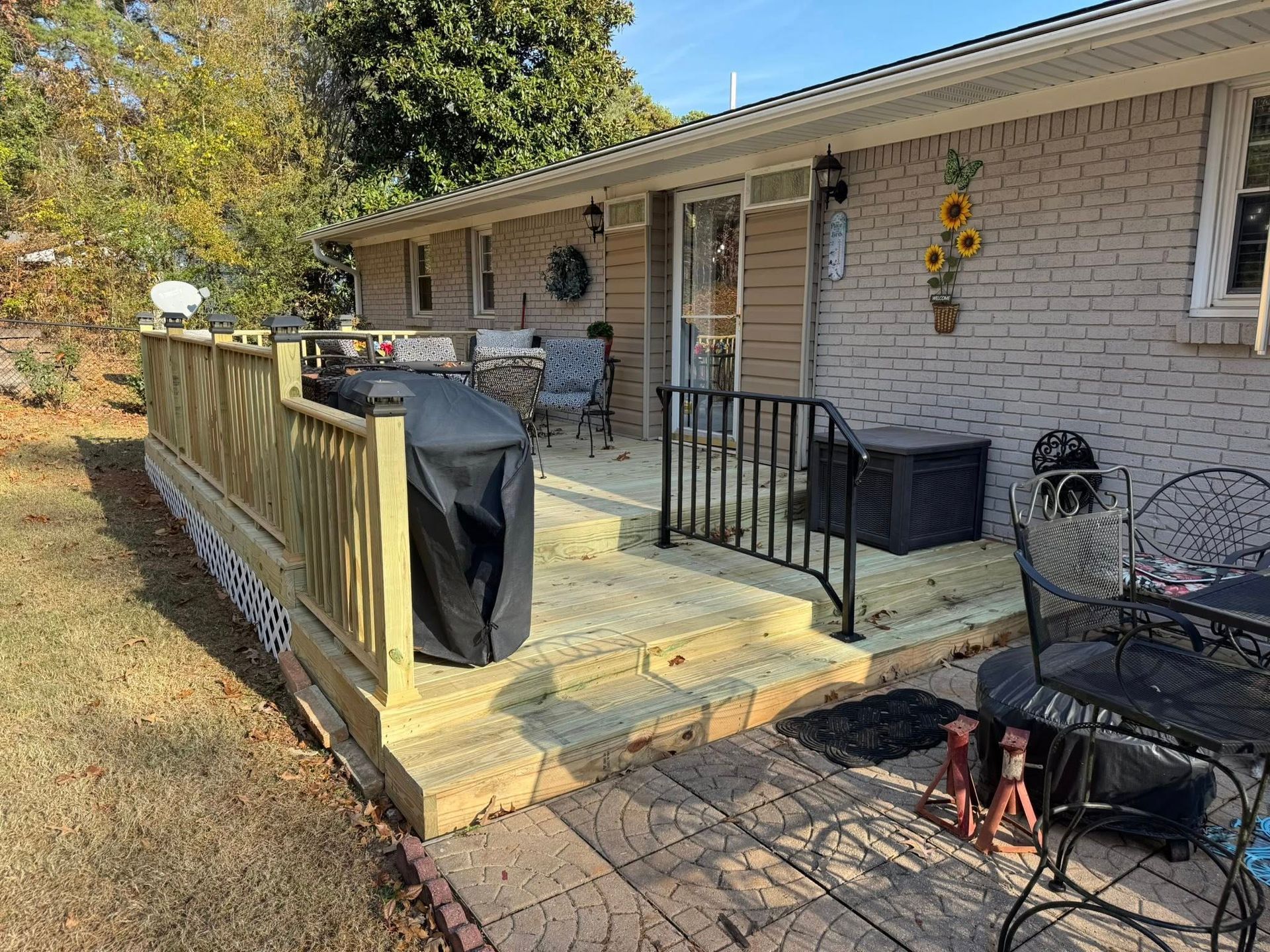 Wooden deck and brick house exterior with outdoor furniture.