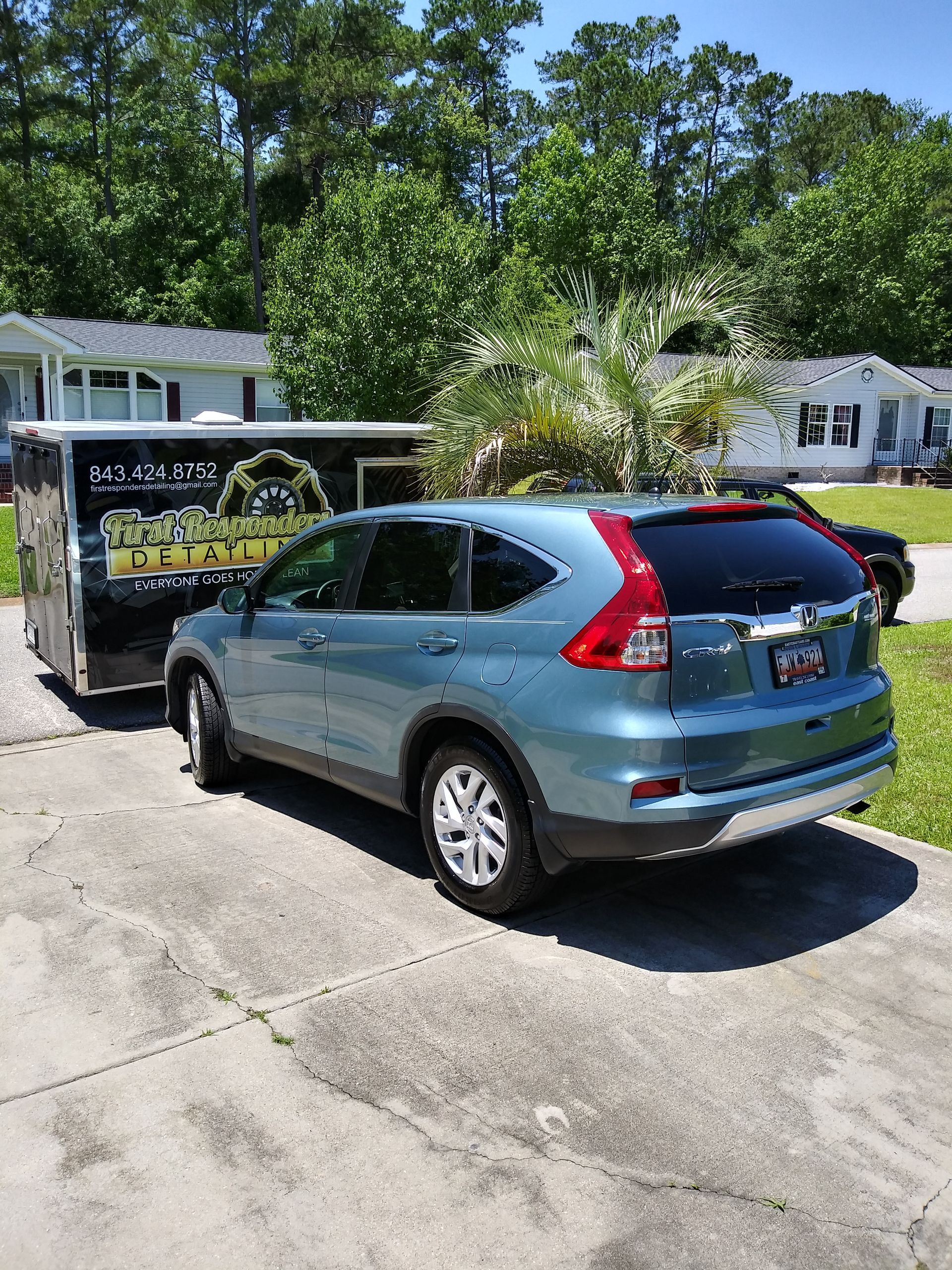 A red cadillac is parked in a garage on a checkered floor.