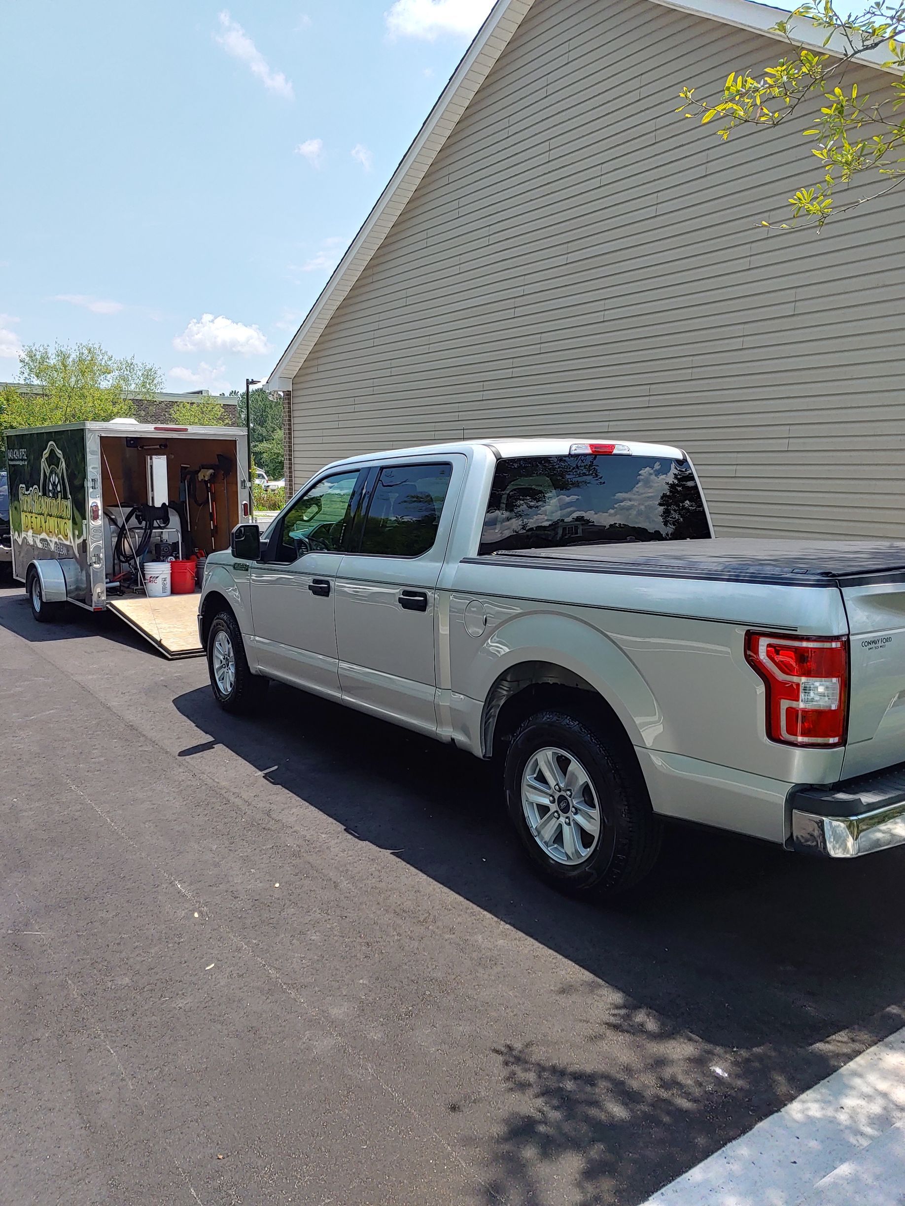 A red cadillac is parked in a garage on a checkered floor.