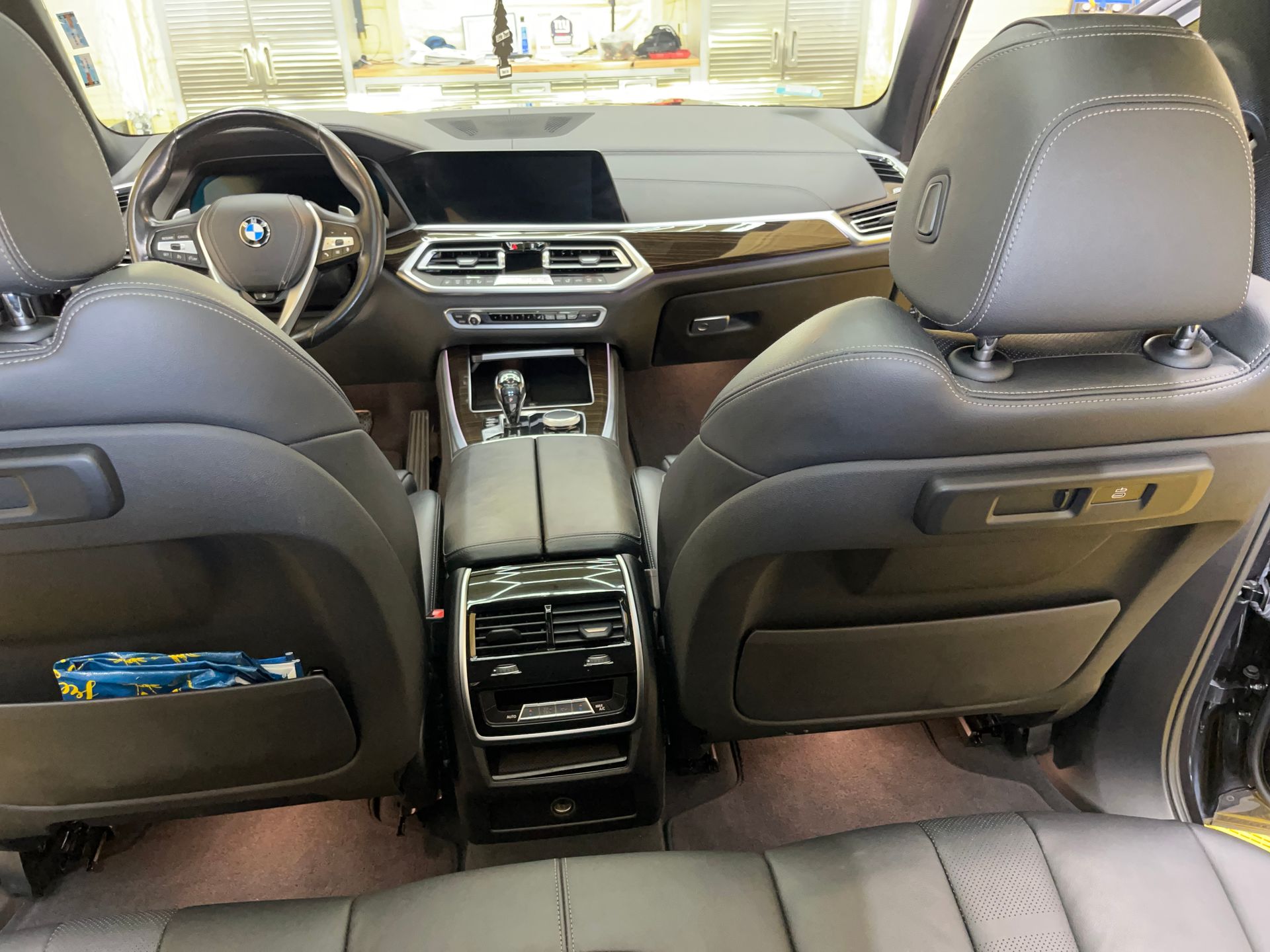 The back seat of a black car with white leather seats