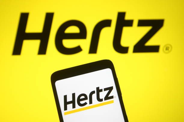 A hertz logo is displayed on a yellow background
