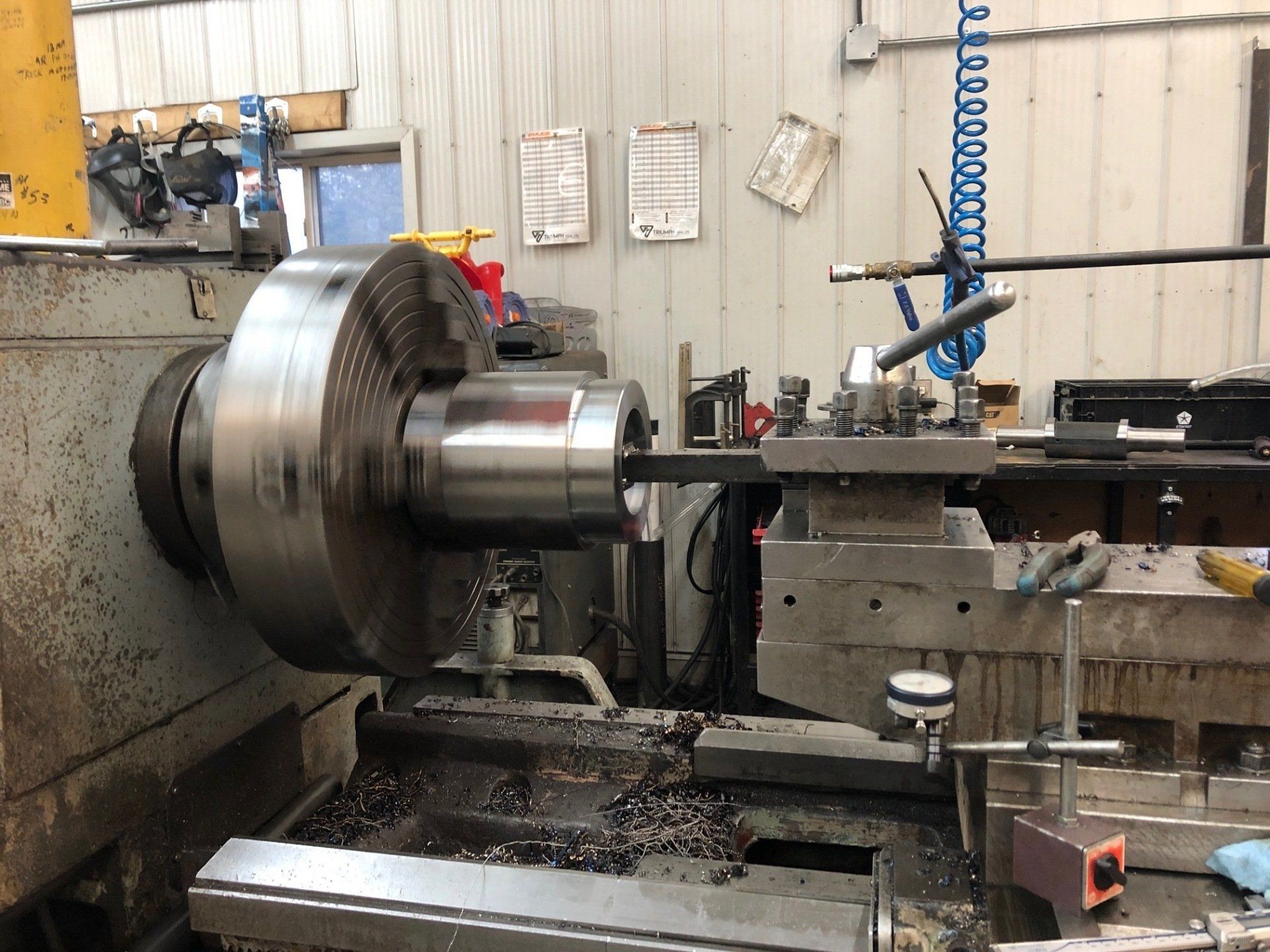 A lathe is being used to cut a piece of metal in a factory.
