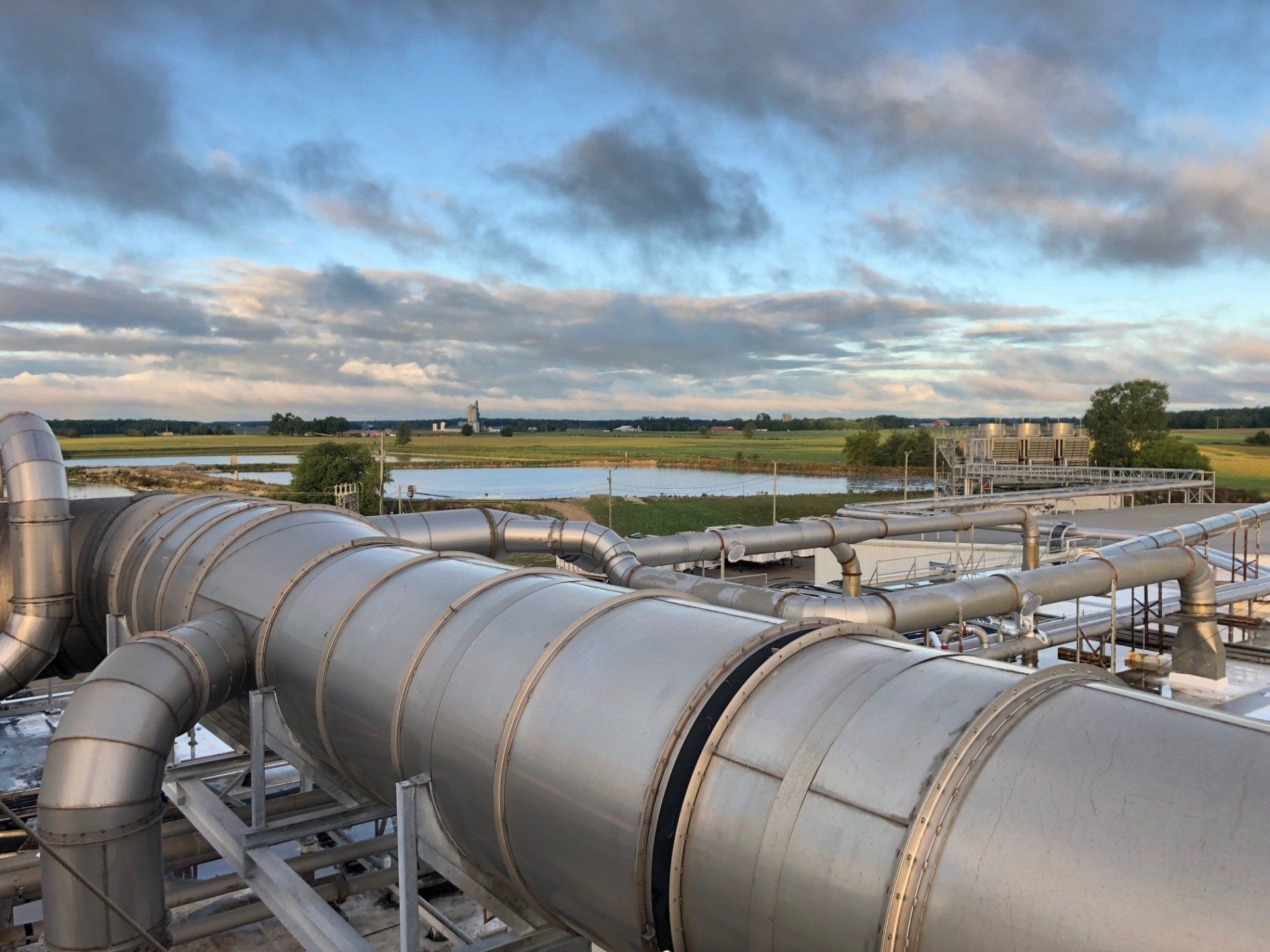 A row of stainless steel pipes are lined up in a factory.