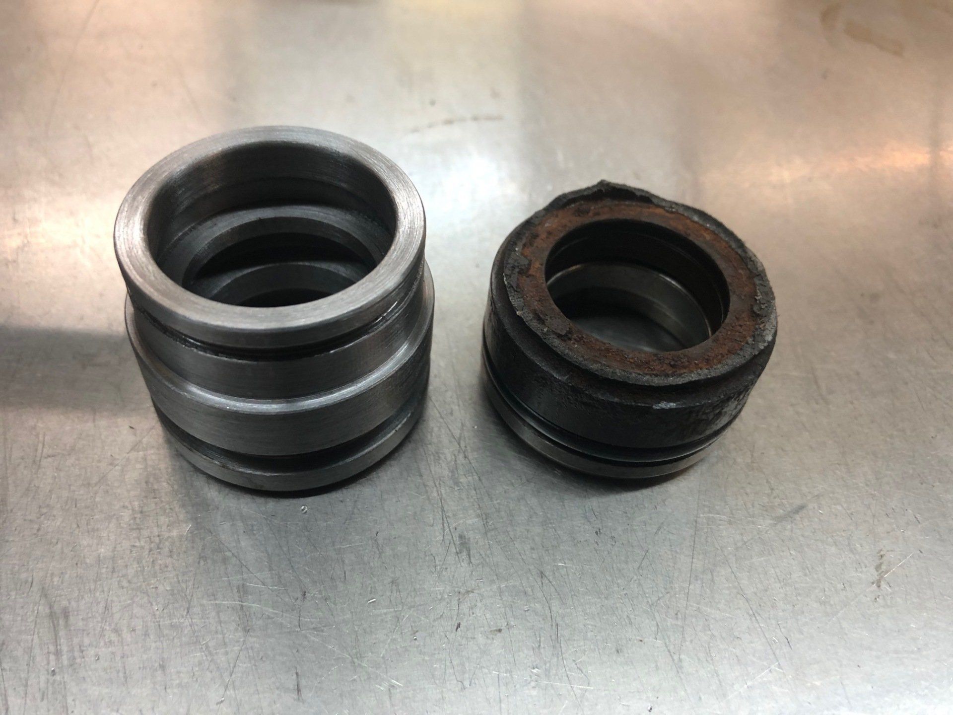 Two metal rings are sitting on a stainless steel table.