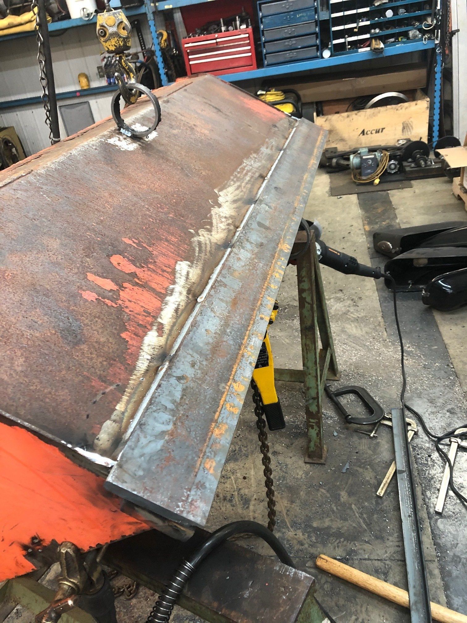 A piece of metal is being worked on in a garage.
