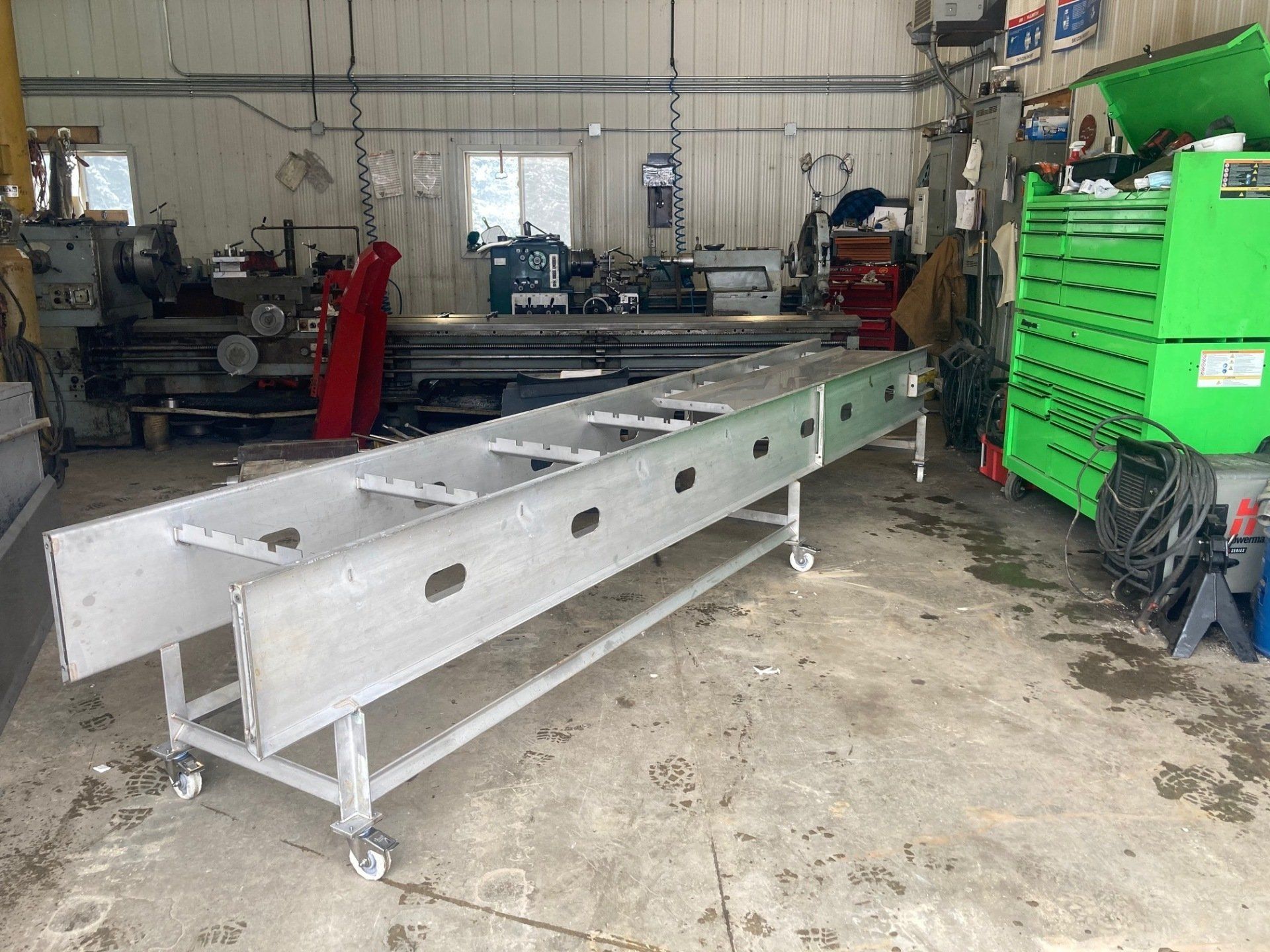 A ladder is sitting on a cart in a garage.