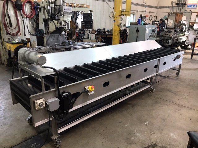 A stainless steel conveyor belt is in a factory