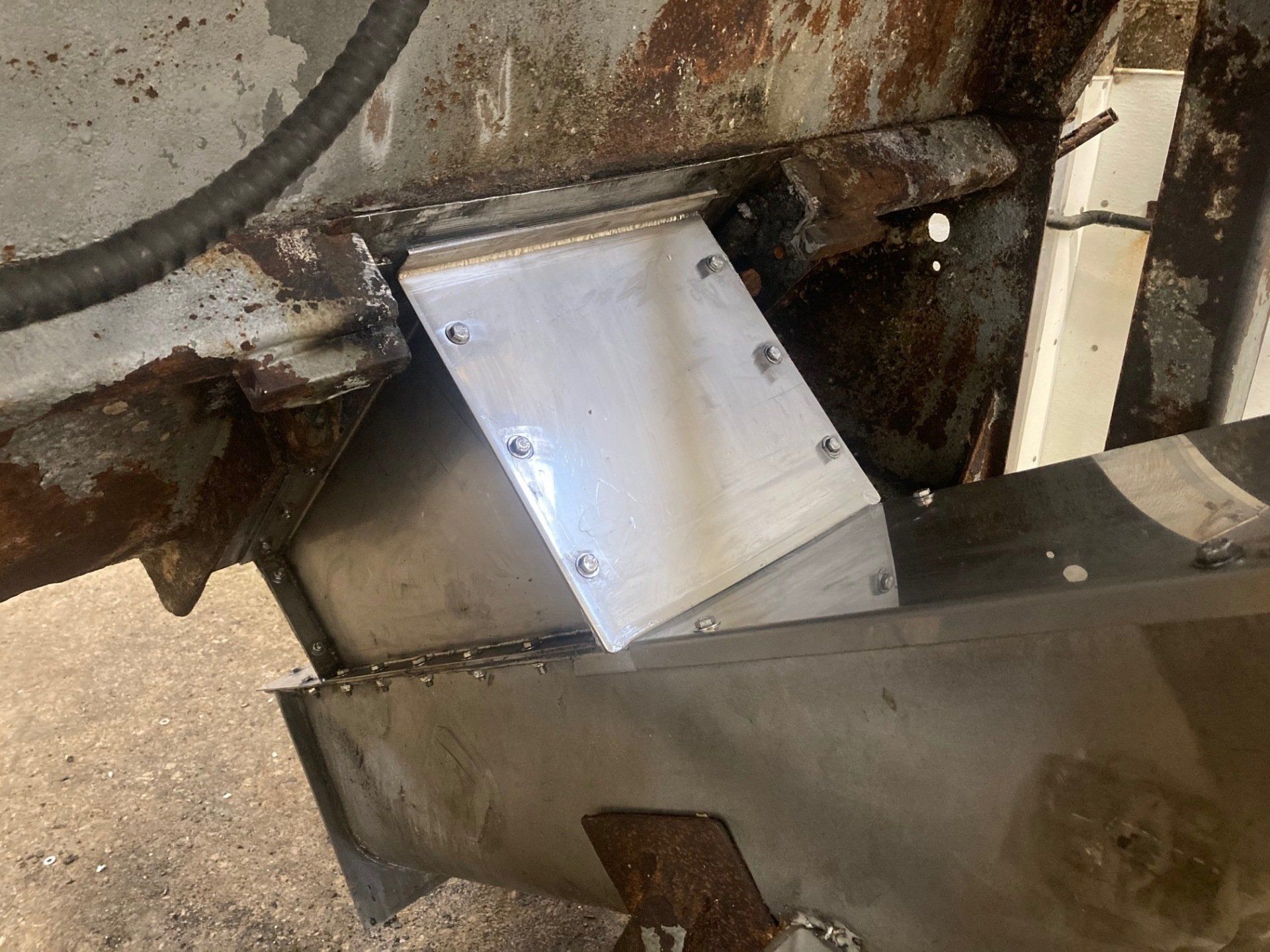 A piece of metal is sitting on top of a rusty piece of metal.