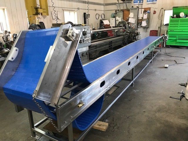 A conveyor belt is sitting on a table in a factory.