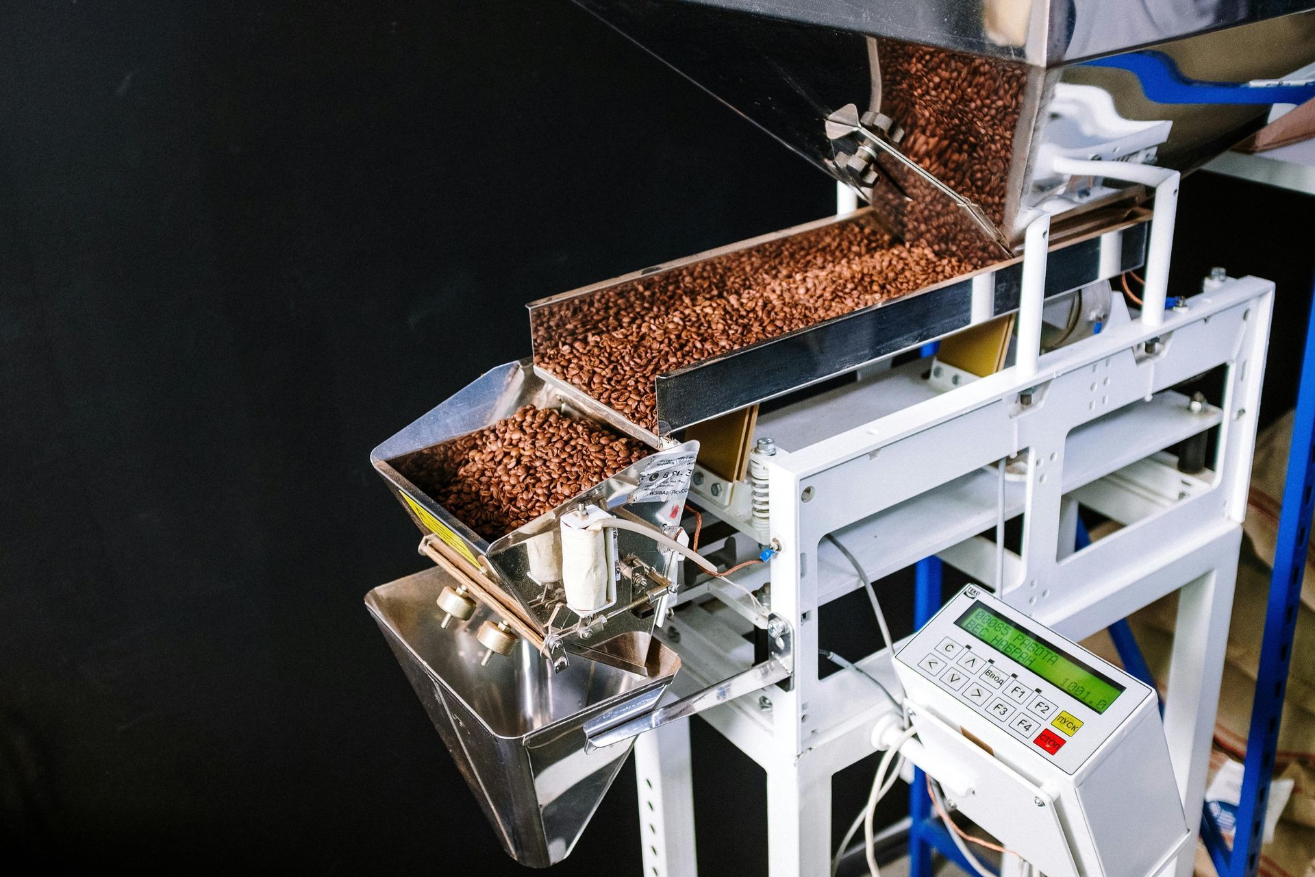 Three white semi-trailer trucks backed up to a loading dock under a blue sky.